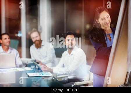 Businesswoman writing on whiteboard Stock Photo