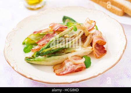 Baked chicory with bacon, onions and herbs. Stock Photo