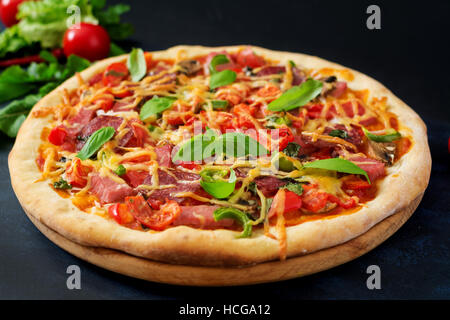 Pizza with salami, ham, tomato, cheese and mushrooms Stock Photo