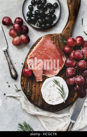 Assorted italian antipasti snacks for a dinner with wine or party on wooden cutting board. Stock Photo