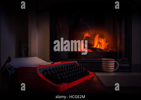 Old typewriter and a cup of coffee in front of fireplace Stock Photo