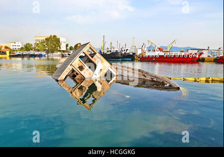 sunken boat reflected on water at Eleusis Greece Stock Photo