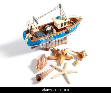 Model fishing boat with shells and starfishes on the white background Stock Photo