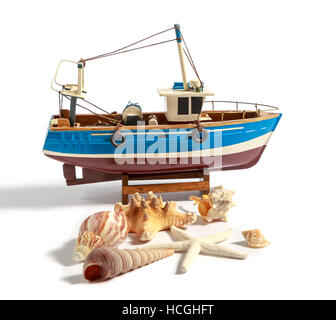 Model fishing boat with shells and starfishes on the white background Stock Photo