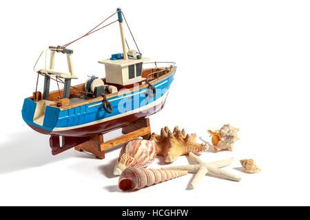 Model fishing boat with shells and starfishes on the white background Stock Photo