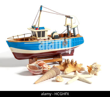 Model fishing boat with shells and starfishes on the white background Stock Photo