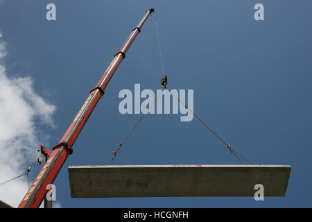 Precast concrete hollow floor slab / plank suspended from a mobile crane. Stock Photo