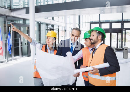 Businessman discussing on blueprint with architects Stock Photo