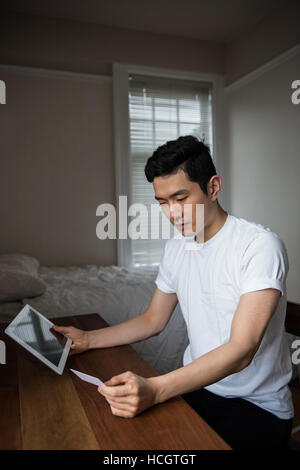 Man doing online shopping on digital tablet Stock Photo