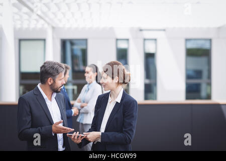 Businesspeople discussing over digital tablet Stock Photo