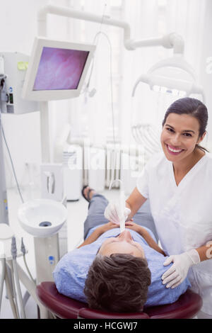 Portrait of female dentist examining patient Stock Photo