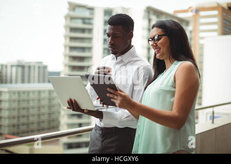 Businessman and a colleague using digital tablet and laptop Stock Photo
