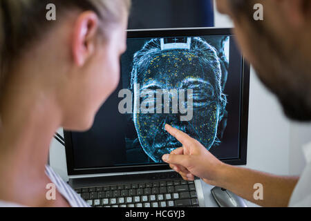 Woman looking mri scan report on computer screen Stock Photo