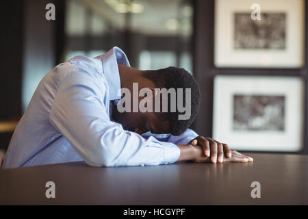 Stressed businessman sitting at his desk Stock Photo