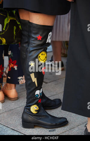 Woman with high leather boots with funny fabric stickers before Cristiano Burani fashion show, Milan Fashion Week street style.