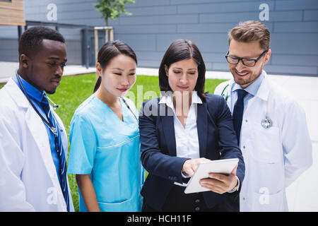 Team of doctors discussing over digital tablet Stock Photo