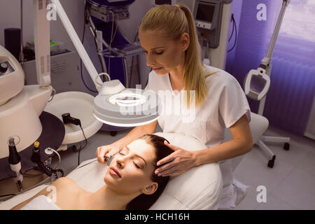 Dermatologist performing laser hair removal on patient Stock Photo