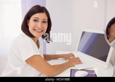 Smiling doctor using desktop pc Stock Photo