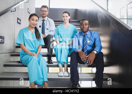Doctors and nurses sitting on staircase Stock Photo