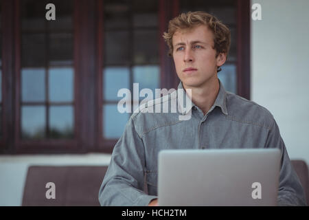 Man using laptop at desk Stock Photo