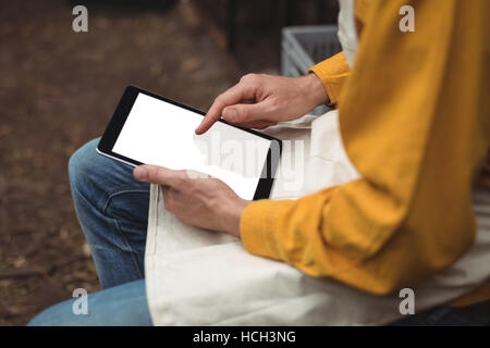 Man in apron using digital tablet while making beer Stock Photo