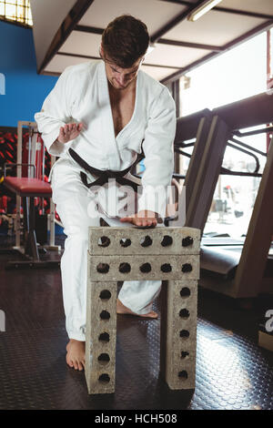 Karate player breaking concrete block Stock Photo