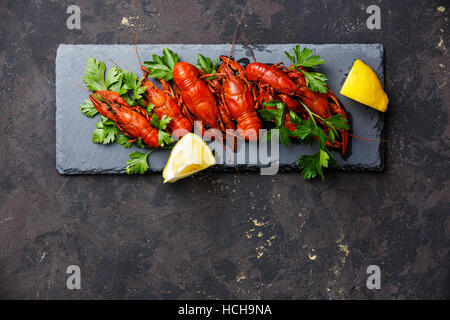 Red boiled crayfish with lemon on stone slate on dark background copy space Stock Photo