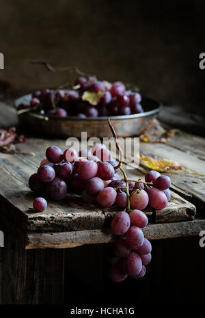 Fresh bunch of red grapes on wooden table Stock Photo