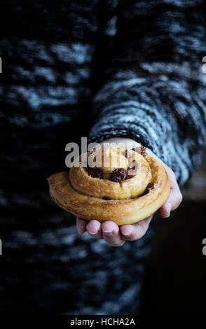 Woman holding a homemade cinnamon roll Stock Photo