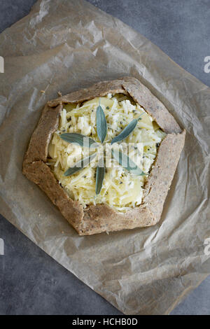 Pie dough and ingredients for a potato galette. Photographed on a greay background from top view. Stock Photo