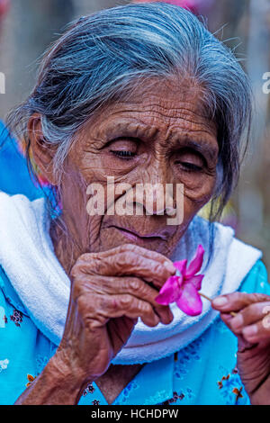 A Salvadoran woman decorates palm fronds with flowers during the Flower & Palm Festival in Panchimalco, El Salvador Stock Photo