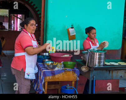 Salvadoran women prepares Popusas in Suchitoto El Salvador. Popusa is a traditional Salvadoran dish made of corn tortilla Stock Photo