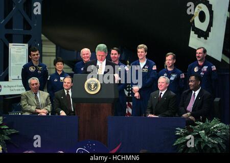 United States President Bill Clinton (at lectern) addresses employees at NASA's Johnson Space Center (JSC) during an April 14, 1998 visit to the Houston facility. Seated behind him (from the left) are JSC Director George W.S. Abbey, U.S. Representative Nick Lampson (Democrat of Texas), NASA Administrator Daniel Goldin and Houston Mayor Lee Brown. Standing are members of the STS-95 crew: (from the left) Pedro Duque, Chiaki Mukai, U.S. Senator John H. Glenn Jr. (Democrat of Ohio), Stephen K. Robinson, Scott E. Parazynski, Steven W. Lindsey and Curtis L. Brown Jr. Brown is commander of the schedu Stock Photo