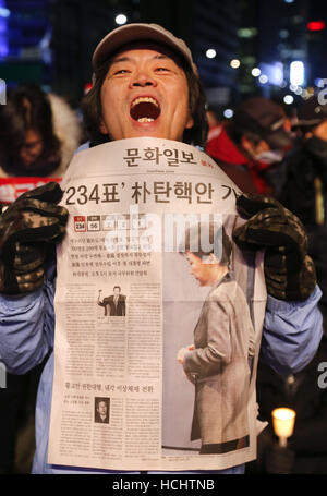 Seoul, South Korea. 9th Dec, 2016. South Korean people carry newspaper reading 'The approving impeachment of president Park Geun-Hye ' during the rally against President Park Geun-Hye on the Gwanghwamun square. Credit:  Min Won-Ki/ZUMA Wire/Alamy Live News Stock Photo