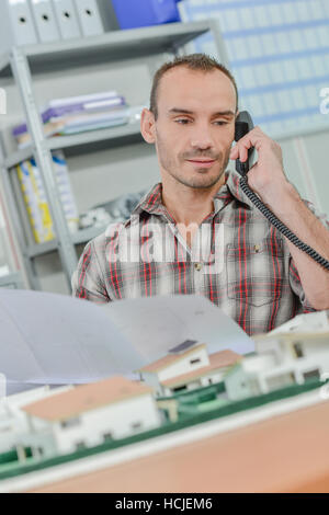 Architect sat with model house Stock Photo