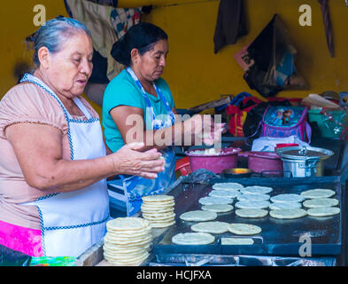 Salvadoran women prepares Popusas in Suchitoto El Salvador. Popusa is a traditional Salvadoran dish made of corn tortilla Stock Photo