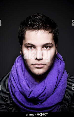 A Young Dark Haired Man Wears A Purple Scarf And Light Eye