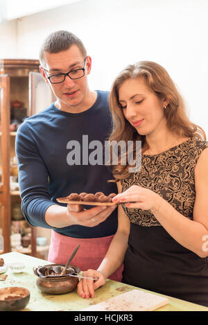 Man and woman preparing chocolate truffles Stock Photo