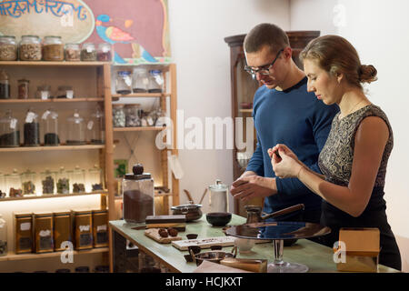 Young men and women are preparing chocolate truffles in a shop Stock Photo