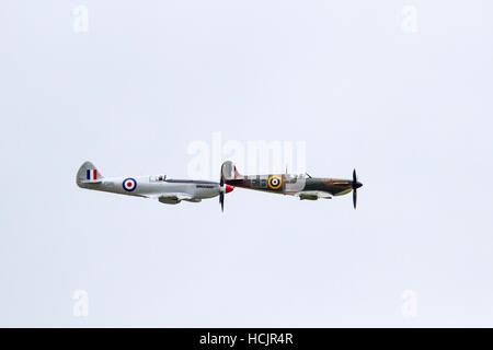 Two versions of the Spitfire aeroplane flying alongside each other at Dunsfold Airshow, surrey England Uk Stock Photo