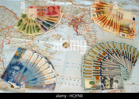 Euro, yuan, us dollars and swiss frank banknotes on map of Greece. Symbolize greek default and foreign interests.