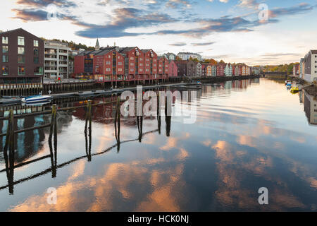 Trondheim, Norway - October 18, 2016: Colorful old wooden houses stand along still river coast in old part of Trondheim Stock Photo