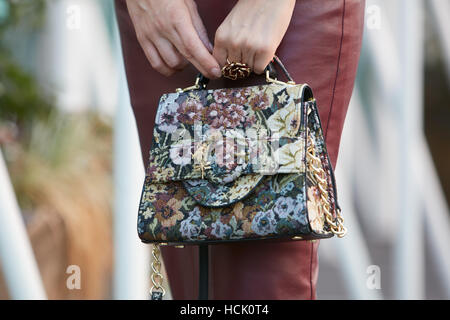 Woman with floral fabric bag before Jil Sander fashion show, Milan Fashion Week street style on September 24, 2016 in Milan.