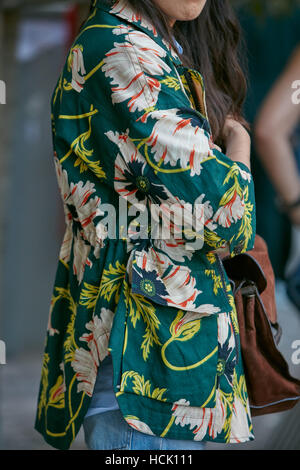 Woman with green shirt with floral decoration before Jil Sander fashion show, Milan Fashion Week street style on September 24. Stock Photo