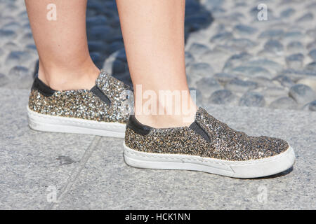 Woman with shoes with golden and silver shiny glitter before Stella Jean fashion show, Milan Fashion Week street style, in Milan