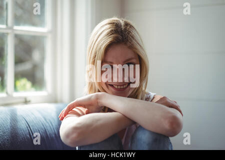 Portrait of happy woman sitting on sofa Stock Photo