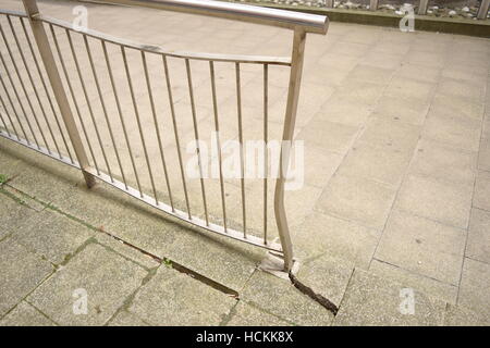 Damaged metal railing on the curb of the road Stock Photo