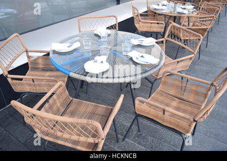 Perspective of wooden chairs around a table in an outdoor restaurant Stock Photo