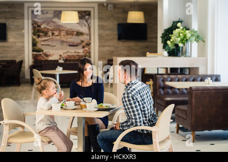 Family sitting together at table in a restaurant Stock Photo