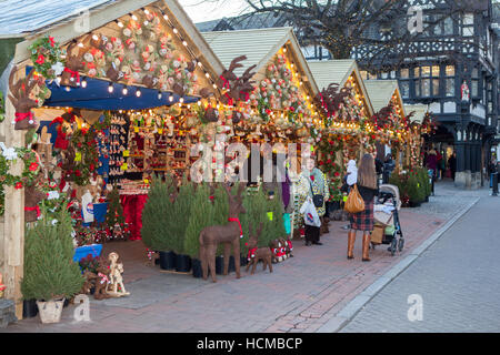 Chalets, Shops, Christmas signs, and shoppers in the retail sector of the City of Chester, Cheshire, UK Stock Photo